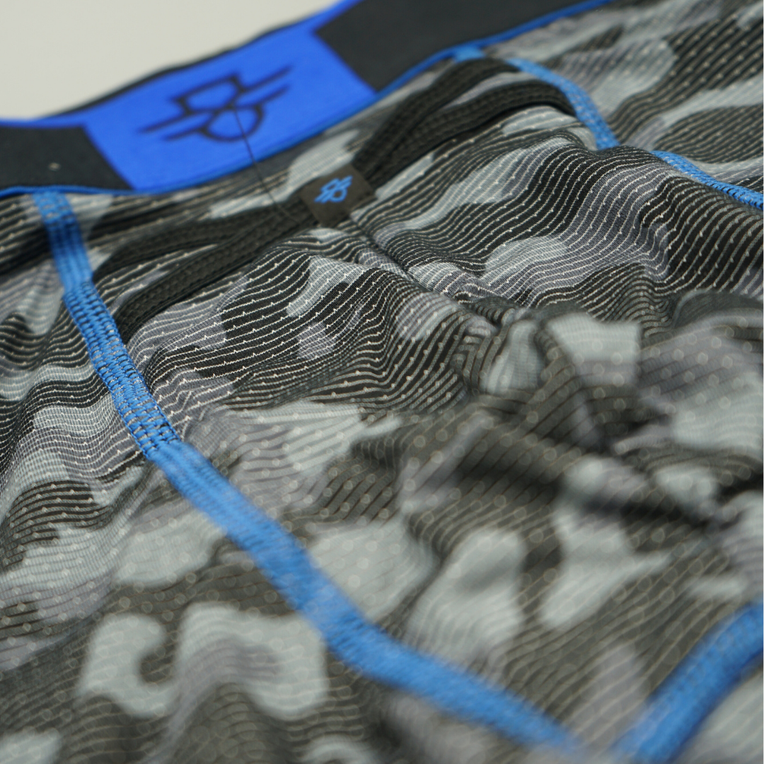 Close-up of camouflage-patterned underwear with blue trim and brand of the Crossfly logo on the Performance Aero Pro 9" Boxers.